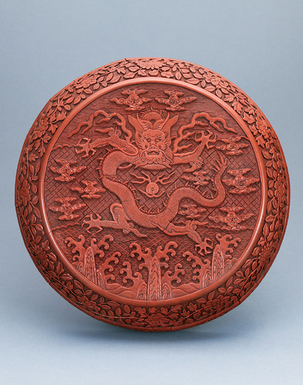 A RED LACQUER BOX, carved with design of dragon riding the waves